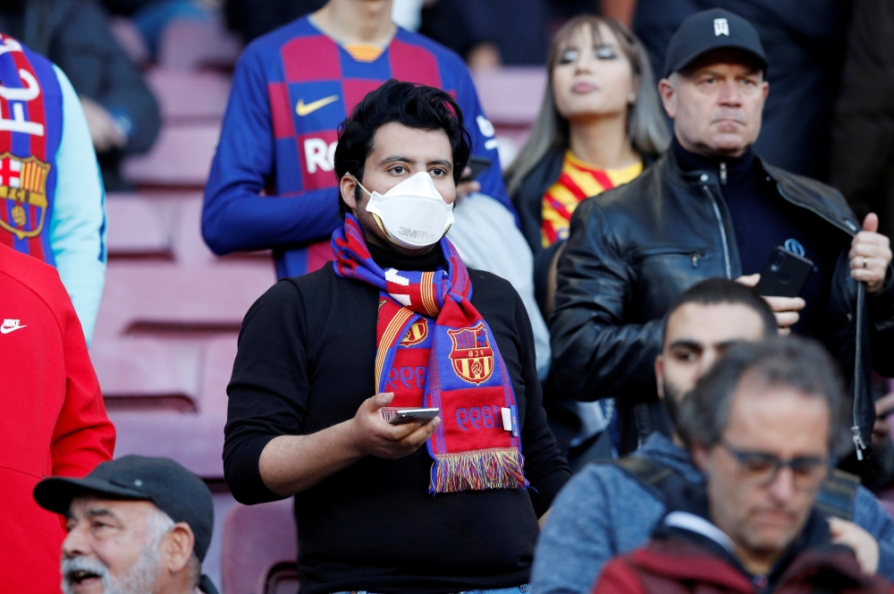 March 7, 2020 A Barcelona fan wears a mask before the match due to the recent coronavirus outbreak REUTERS/Albert Gea/File Photo