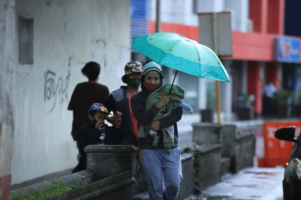 An evacuating family waits for instructions from village officials in the coastal area of Legaspi City, Albay province south of Manila on october 25, 2020, ahead of tropical storm Molave's expected landfall. / AFP / Charism SAYAT