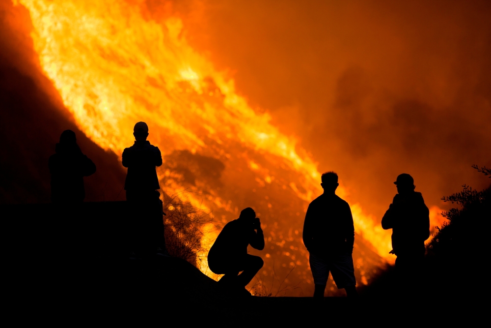 Residents are silhouetted as they watch the Blue Ridge Fire burning in Yorba Linda, California, U.S. October 26, 2020. REUTERS/Ringo Chiu
