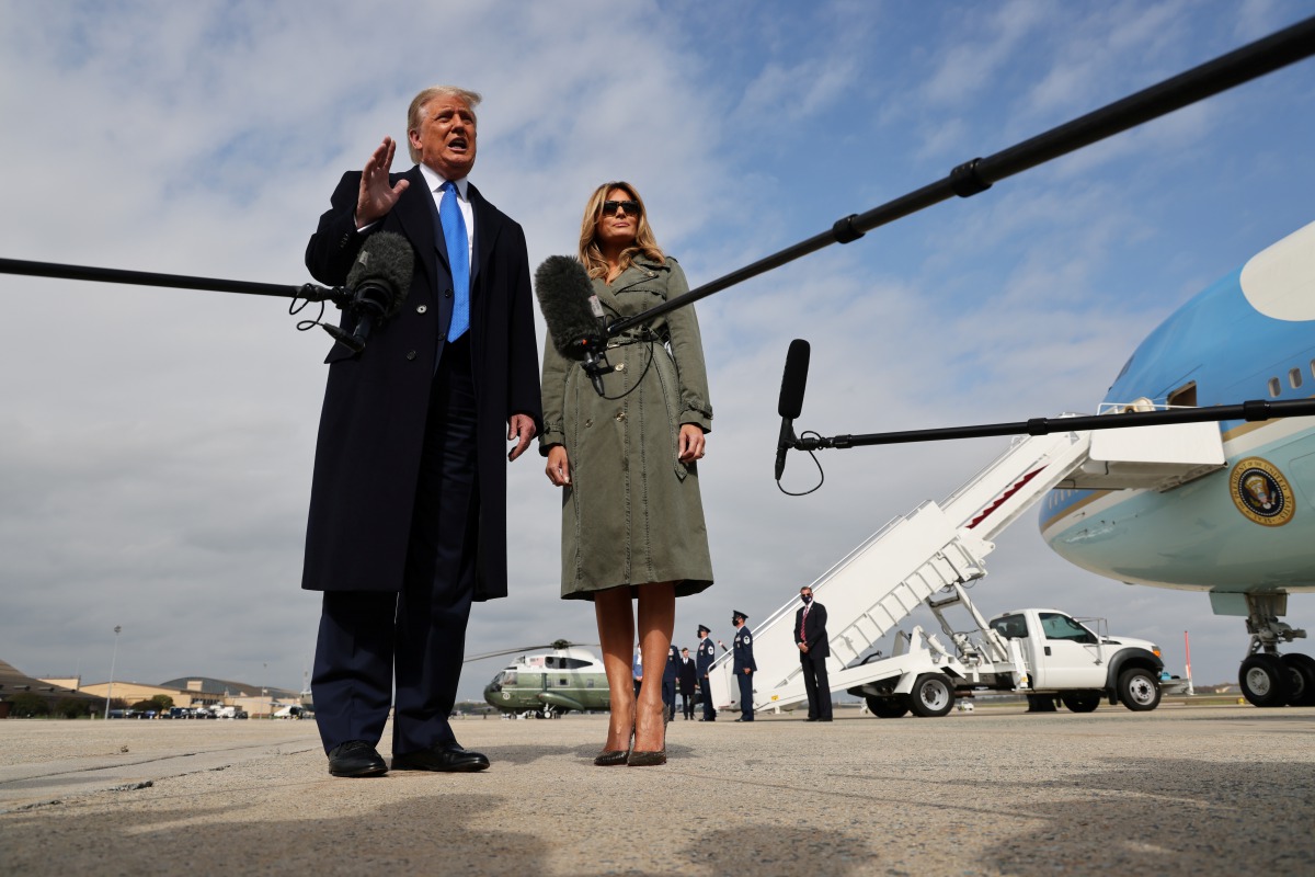 U.S. President Donald Trump talks to reporters with first lady Melania Trump while boarding Air Force One as they depart Washington for campaign travel to Michigan at Joint Base Andrews, Maryland, U.S., October 27, 2020. REUTERS/Jonathan Ernst
