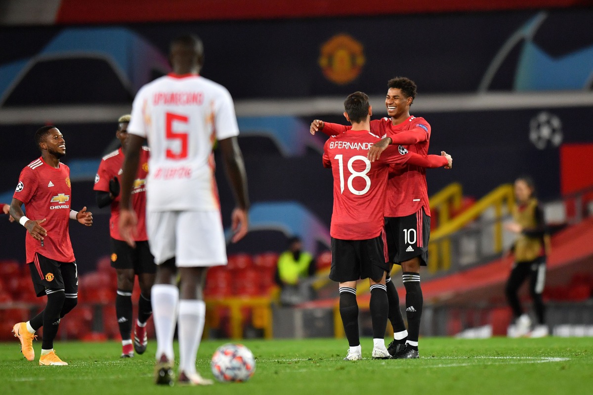 Manchester United's English striker Marcus Rashford (R) celebrates scoring his team's third goal, his second, with Manchester United's Portuguese midfielder Bruno Fernandes, during the UEFA Champions league group H football match between Manchester United
