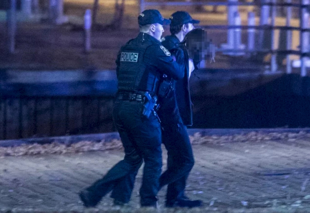 Police officers detain a man near the National Assembly of Quebec, in Quebec City, early on November 1, 2020, after two people were killed and five wounded by a sword-wielding suspect dressed in medieval clothing. AFP / Jordan Proust