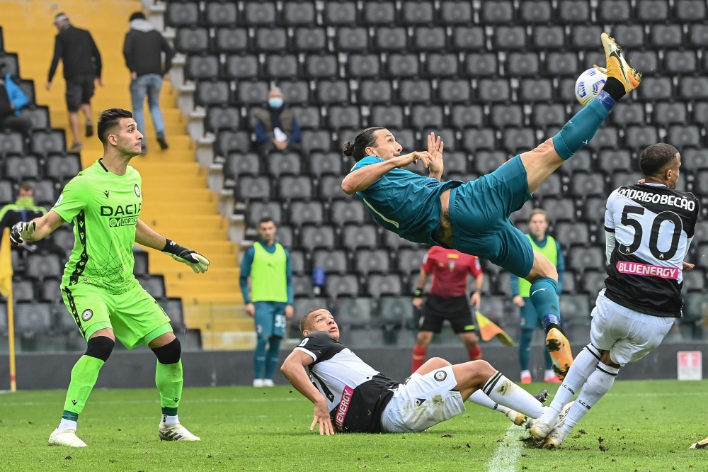 AC Milan's Swedish forward Zlatan Ibrahimovic (R) shoots and scores during the Italian Serie A football match between Udinese and AC Milan at the Friuli Stadium, alias 