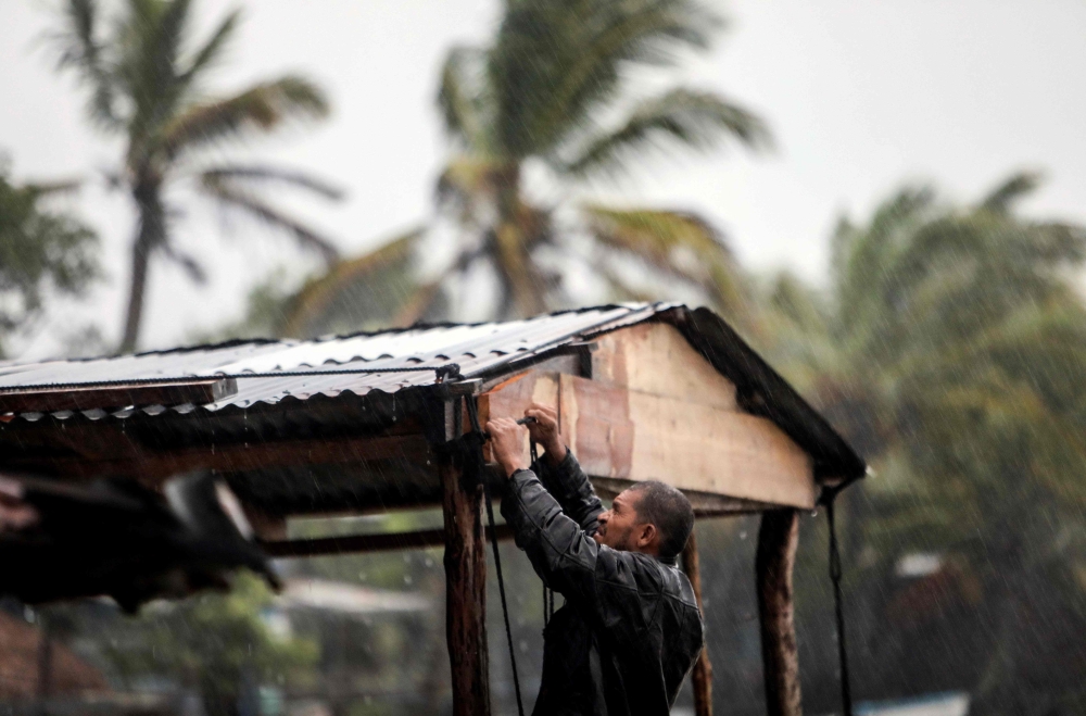 A man protects his beach house as Hurricane Eta approaches in Bilwi, Puerto Cabezas, Nicaragua, on November 2, 2020. AFP / INTI OCON
