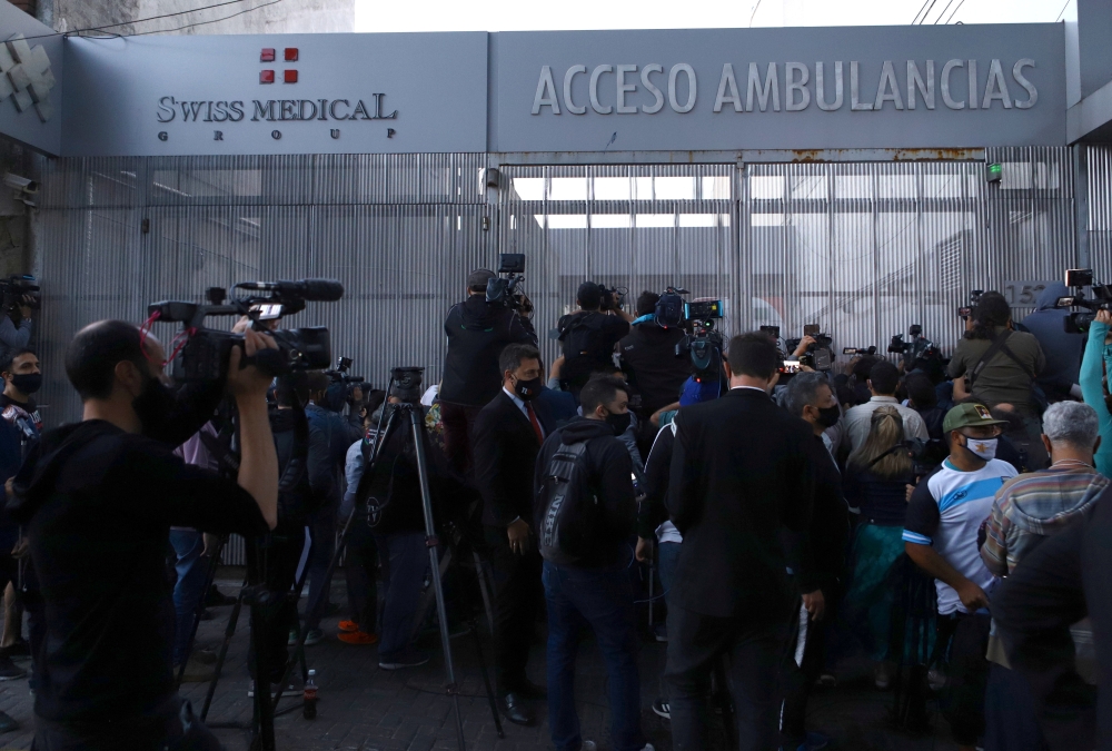 Reporters and fans of Argentine soccer great Diego Maradona gather outside the clinic where he will be undergoing surgery, in Olivos, on the outskirts of Buenos Aires, Argentina November 3, 2020. REUTERS/Matias Baglietto