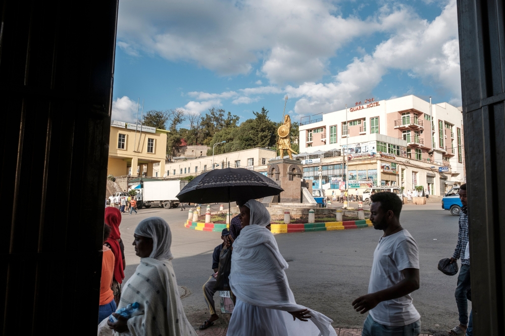 People walk near a square of Emperor Tewodros II in the city of Gondar, Ethiopia, on November 06, 2020. / AFP / EDUARDO SOTERAS