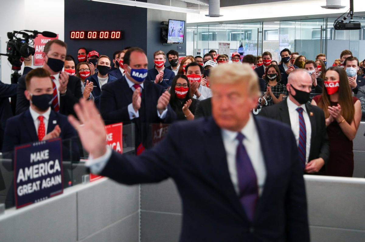 U.S. President Donald Trump's campaign staff applaud him as he waves after speaking to them while visiting his presidential campaign headquarters on Election Day outside of Washington in Arlington, Virginia, U.S., November 3, 2020. REUTERS/Tom Brenner
