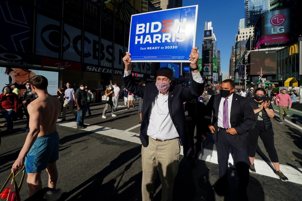 Senate Minority Leader Chuck Schumer (D-NY) carries a campaign placard after media announced that Democratic US presidential nominee Joe Biden has won the 2020 US presidential election, on Times Square in New York City, US, November 7, 2020. Reuters/Carlo