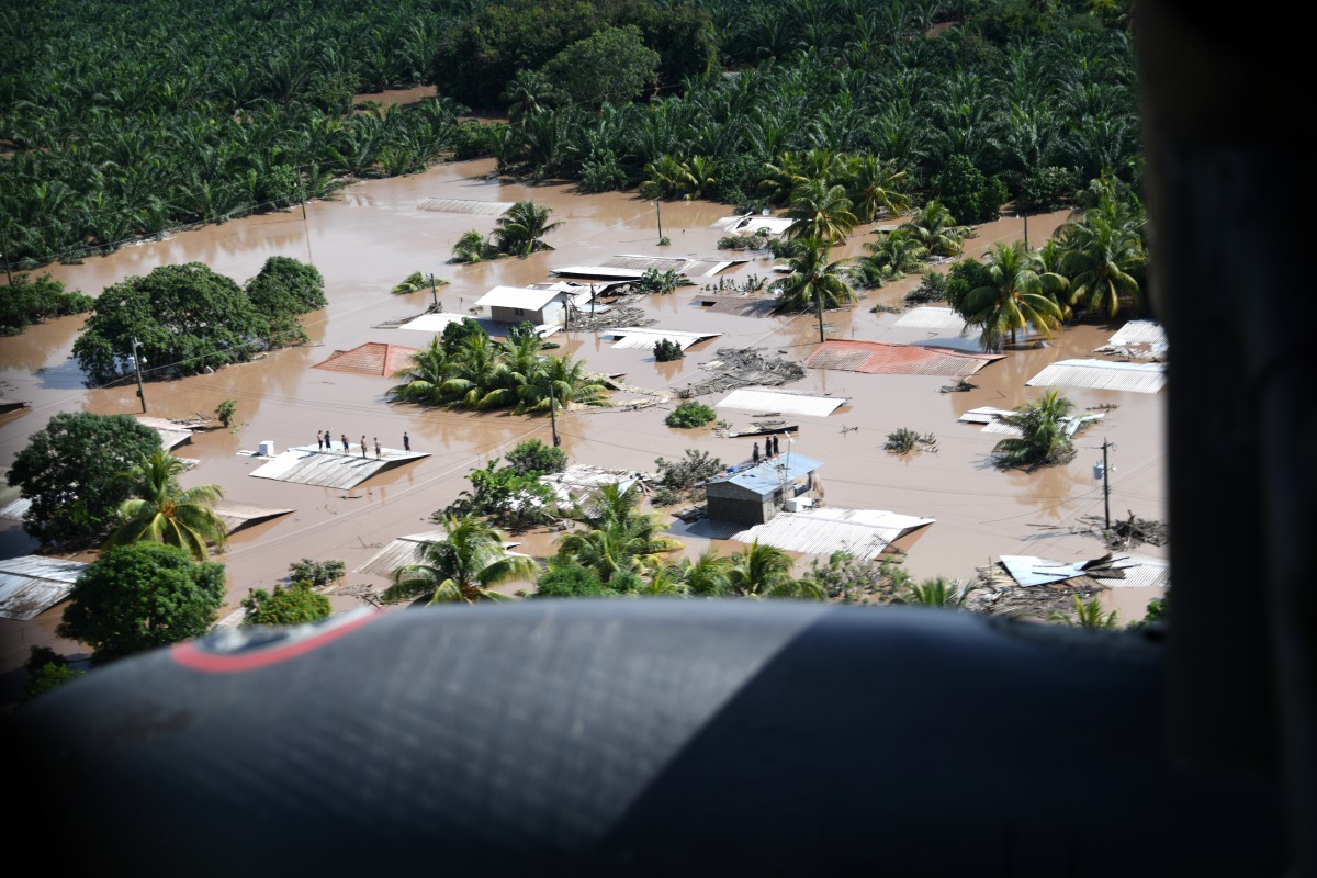 Hondurans stand on rooftops surrounded by the floodwaters of Hurricane Eta in San Pedro Sula, Honduras, November 7, 2020. Picture taken November 7, 2020. U.S. Air Force/Staff Sgt. Elijaih Tiggs/Handout via REUTERS. THIS IMAGE HAS BEEN SUPPLIED BY A THIRD 