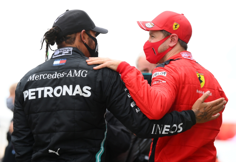 Mercedes' Lewis Hamilton is congratulated by Ferrari's Sebastian Vettel after winning the race and the world championship REUTERS/Clive Mason