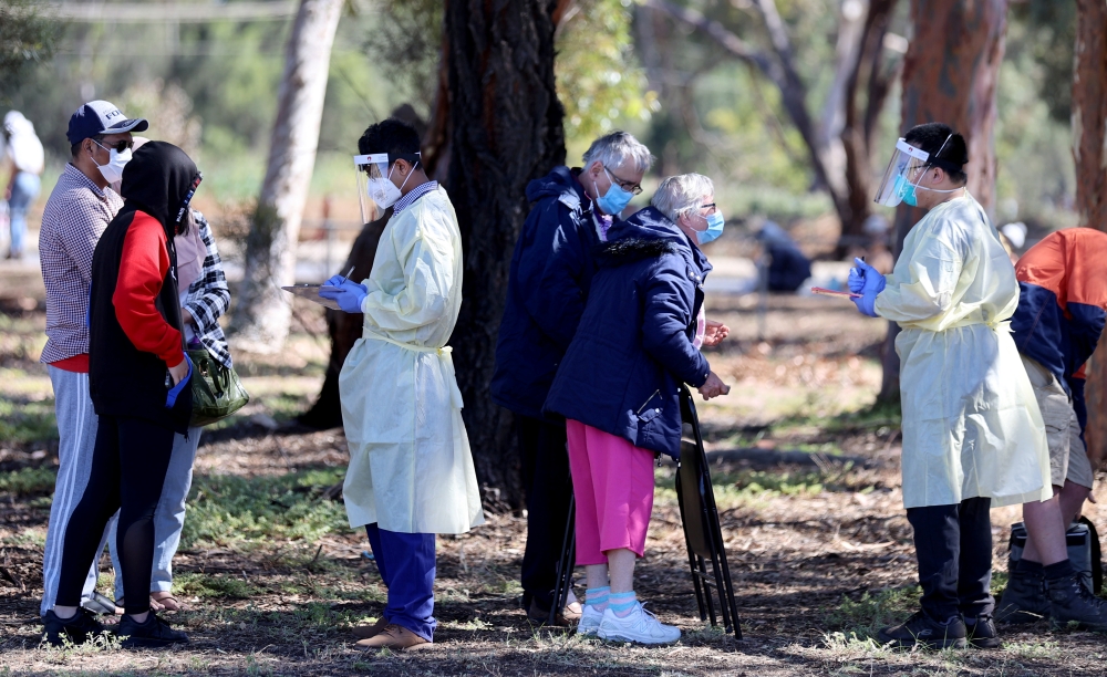 Medical staff members take details from people queuing at a coronavirus disease (COVID-19) testing site as the state of South Australia experiences an outbreak, in Adelaide, Australia, November 17, 2020. AAP Image/Kelly Barnes via REUTERS
