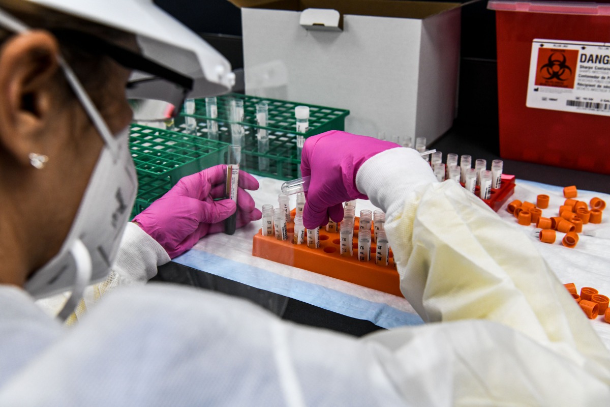 (FILES) In this file photo taken on August 13, 2020, a lab technician sorts blood samples inside a lab for a Covid-19 vaccine study at the Research Centers of America (RCA) in Hollywood, Florida. A key facet of the global mad scramble by Pfizer, moderna a