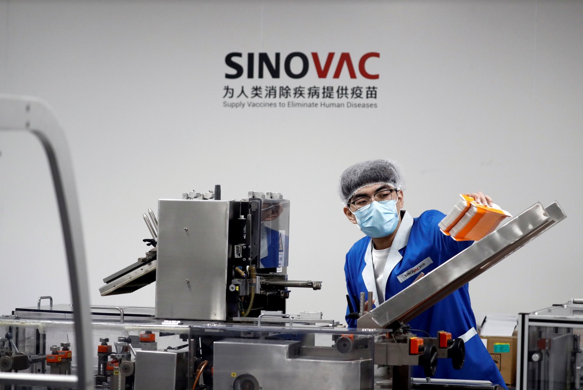 FILE PHOTO: A man works in the packaging facility of Chinese vaccine maker Sinovac Biotech, developing an experimental coronavirus disease (COVID-19) vaccine, during a government-organized media tour in Beijing, China, September 24, 2020. REUTERS/Thomas P