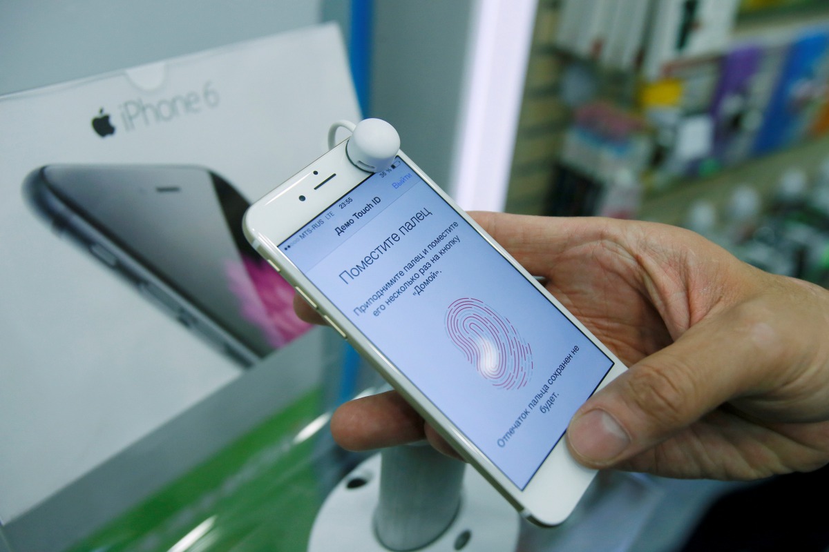 FILE PHOTO: A man holds an iPhone 6 in a mobile phone shop in Moscow, Russia, September 26, 2014. REUTERS/Maxim Shemetov/File Photo
