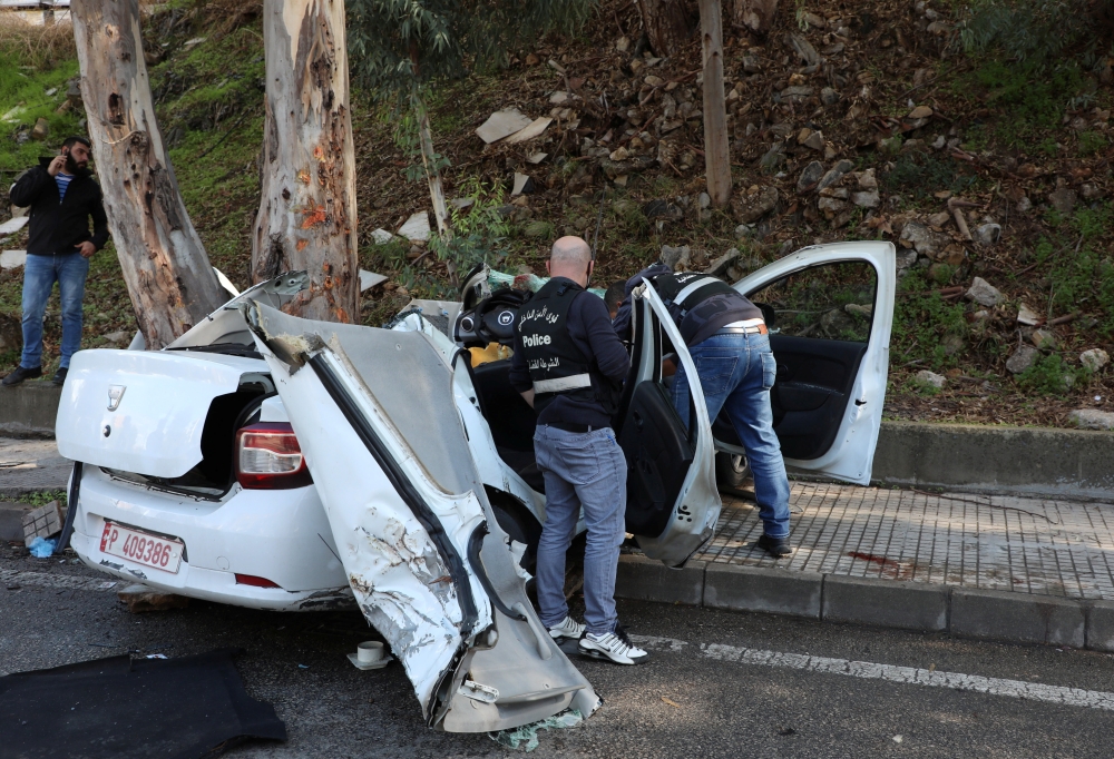Members of the Lebanese police inspect the damaged car in Hadath, Lebanon, November 21, 2020. REUTERS/Mohamed Azakir