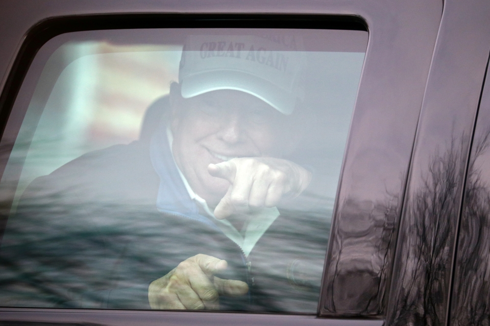 US President Donald Trump gestures as his motorcade leaves the Trump National Golf Club in Sterling, Virginia, US, November 22, 2020. Reuters/Hannah McKay