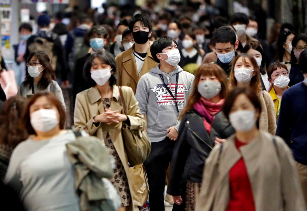 People wearing protective face masks walk on the street, amid the coronavirus disease (COVID-19) outbreak, in Tokyo, Japan November 19, 2020. Reuters/Issei Kato/File Photo
