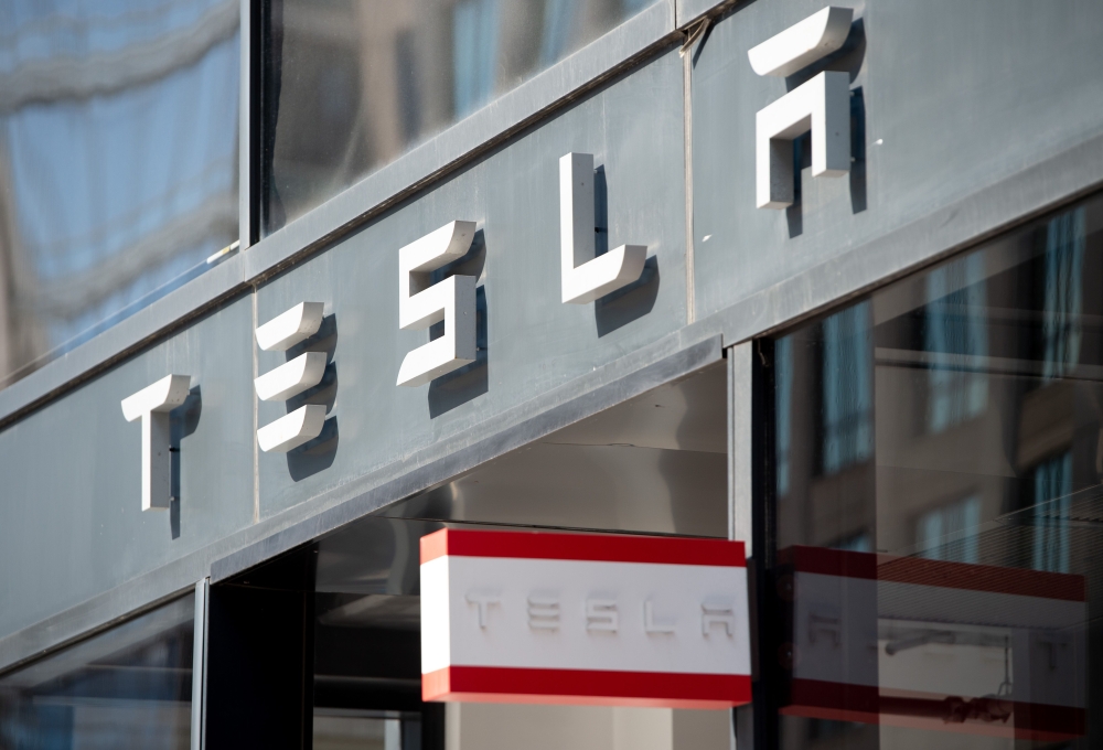 In this file photo taken on August 8, 2018 The Tesla logo is seen outside of their showroom in Washington, DC. Tesla's market value soared to more than $500 billion Tuesday ahead of its listing on the S&P 500, with its stock finishing up 6.4 percent or by