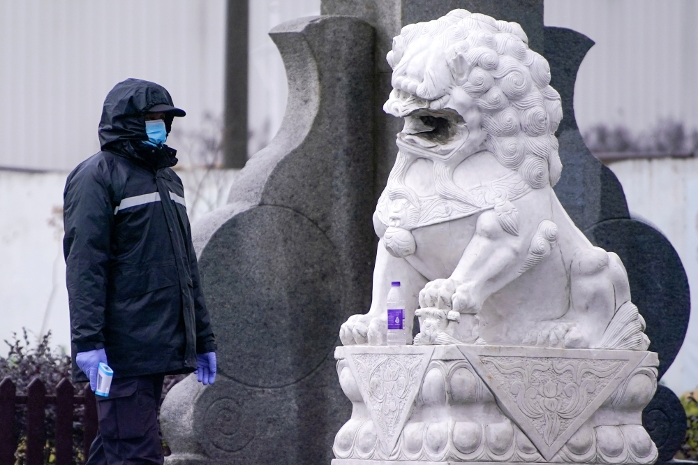 A security guard holds a thermometer at Yingqian village of Pudong district, amid the global outbreak of the coronavirus disease (COVID-19), in Shanghai, China November 25, 2020. REUTERS/Aly Song