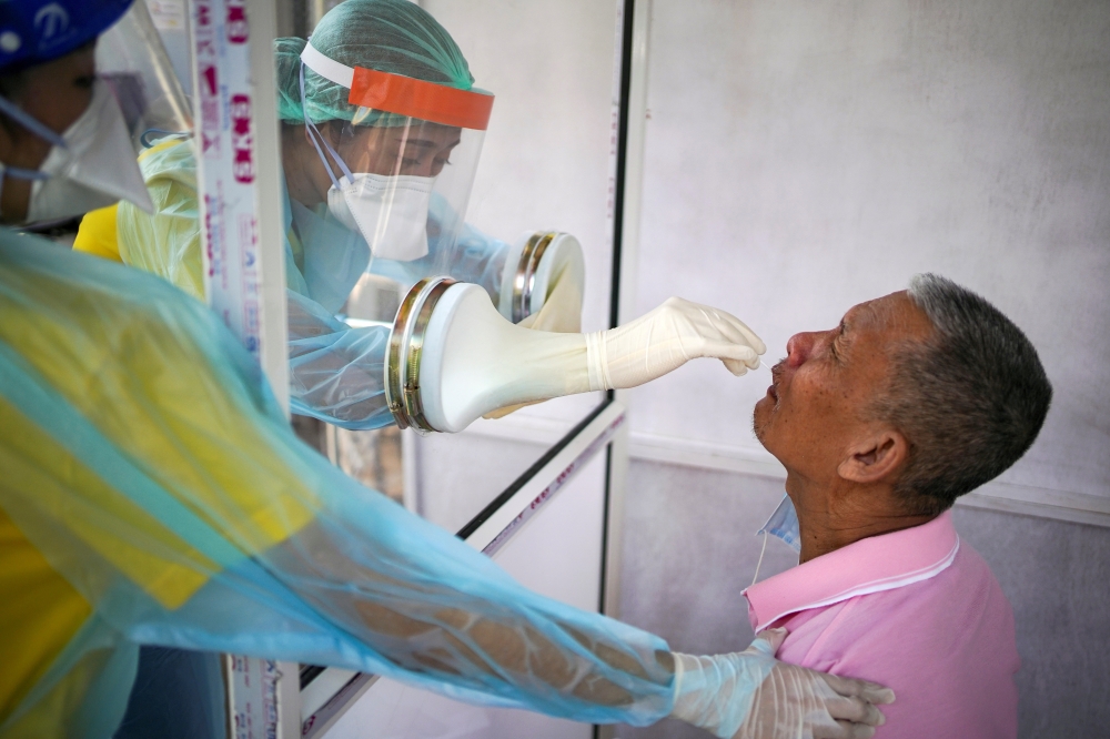 FILE PHOTO: Medical personnel perform a nose swab test on a local resident of a community in Bangkok, amid the coronavirus disease (COVID-19) outbreak in Thailand, April 28, 2020. REUTERS/Athit Perawongmetha