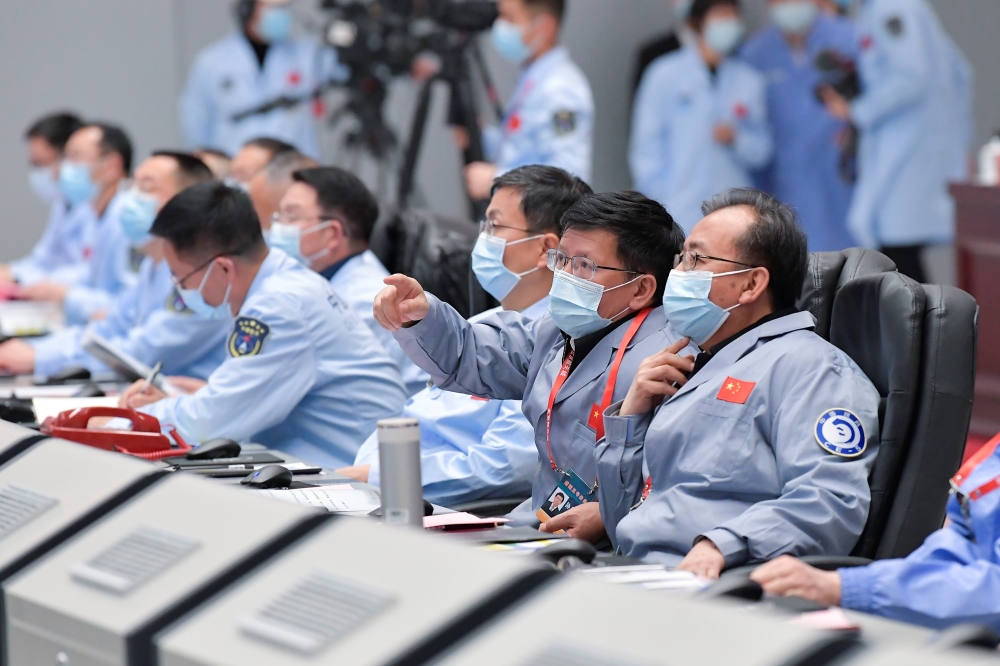 This photo taken on December 1, 2020 shows technical personnel monitoring the process during the Chang'e-5 lunar probe landing on the moon at the Beijing Aerospace Control Center in Beijing. An unmanned Chinese spacecraft landed on the Moon on December 1,
