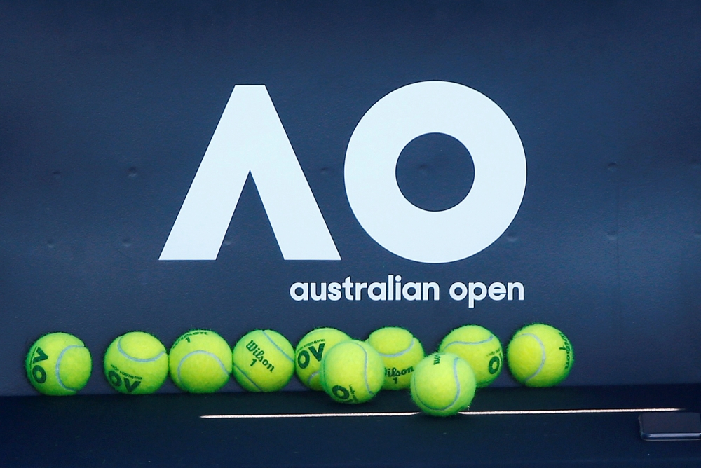Tennis balls are pictured in front of the Australian Open logo before the tennis tournament. REUTERS/Thomas Peter/File Photo