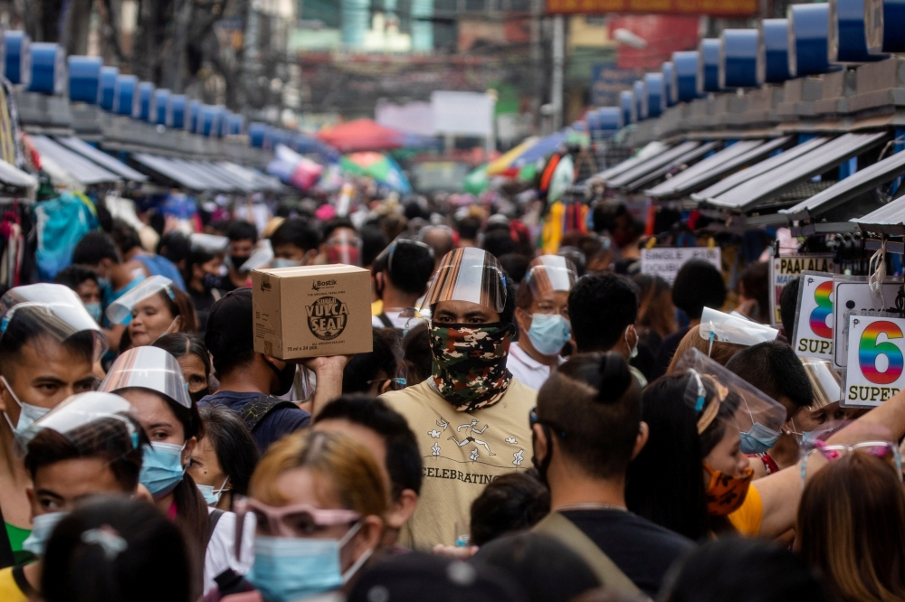 Filipinos wearing masks and face shields for protection against the coronavirus disease (COVID-19) walk along a street market in Manila, Philippines, December 3, 2020. Reuters/Eloisa Lopez