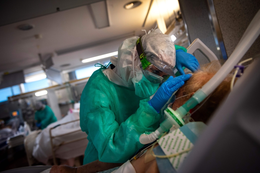 A healthcare worker attends to a COVID-19 coronavirus patient at the Intensive Unit Care of the Povisa Hospital in Vigo, northwestern Spain, on April 16, 2020.  AFP / MIGUEL RIOPA