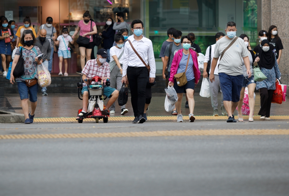 People wearing protective face masks cross a street, in Singapore, November 30, 2020. Reuters/Edgar Su