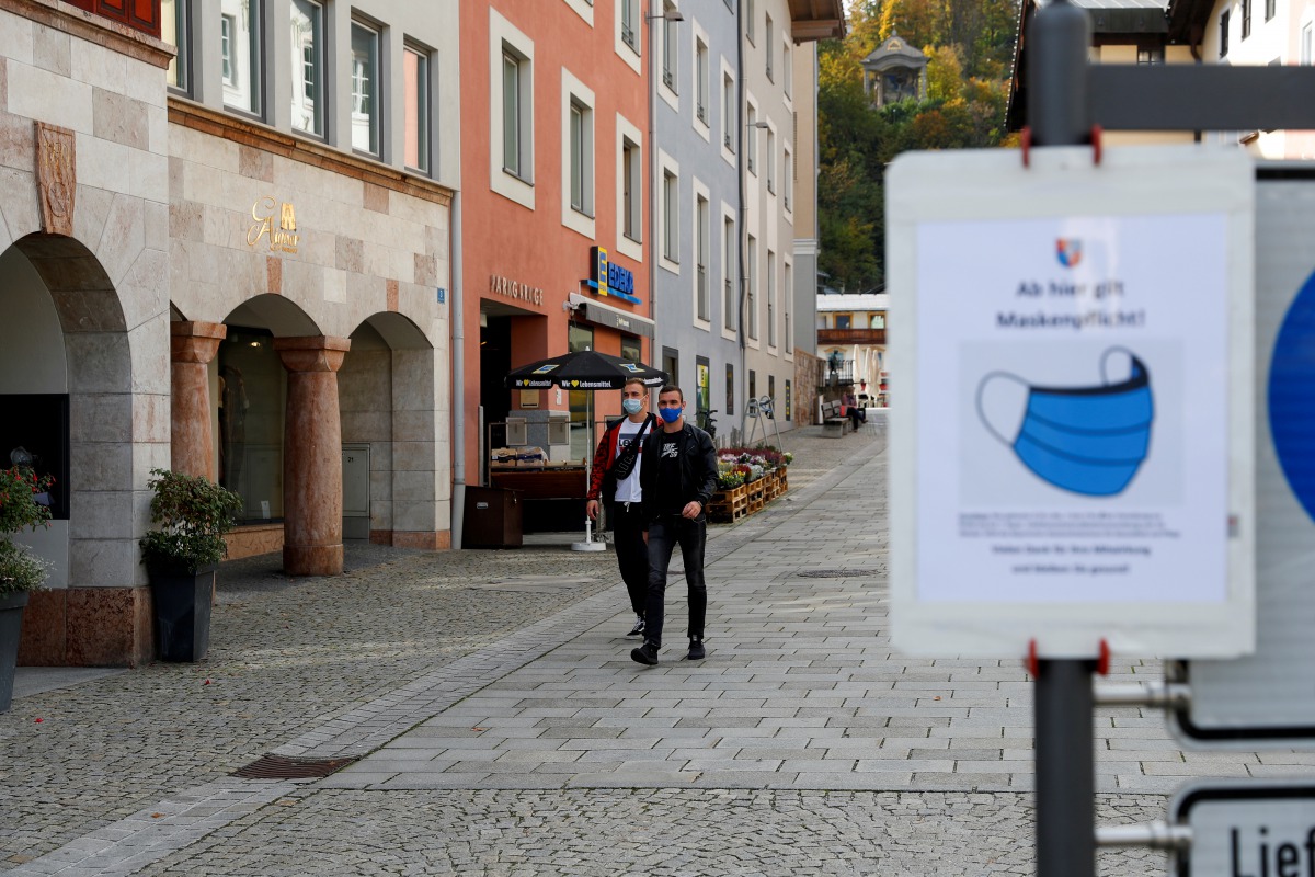 FILE PHOTO: Men wearing protective face masks walk after residents of the Berchtesgadener Land district of Bavaria will not be able to leave their homes from October 20, 2020, without a valid reason for two weeks, making it the first area in Germany to go
