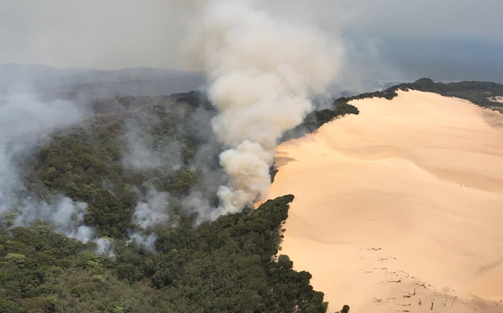 An aerial view shows smoke following a massive bushfire in Australia's Fraser Island, also known by its indigenous name K'gari, November 30, 2020, in this picture obtained from social media. Queensland Fire and Emergency Services via REUTERS/File Photo