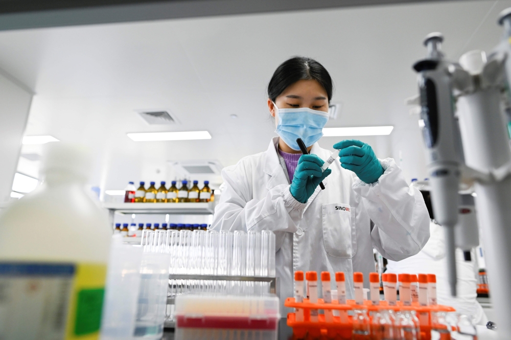 This file photo taken on September 24, 2020 shows an engineer working in the general laboratory during a media tour of a new factory built to produce a Covid-19 coronavirus vaccine at Sinovac, one of 11 Chinese companies approved to carry out clinical tri
