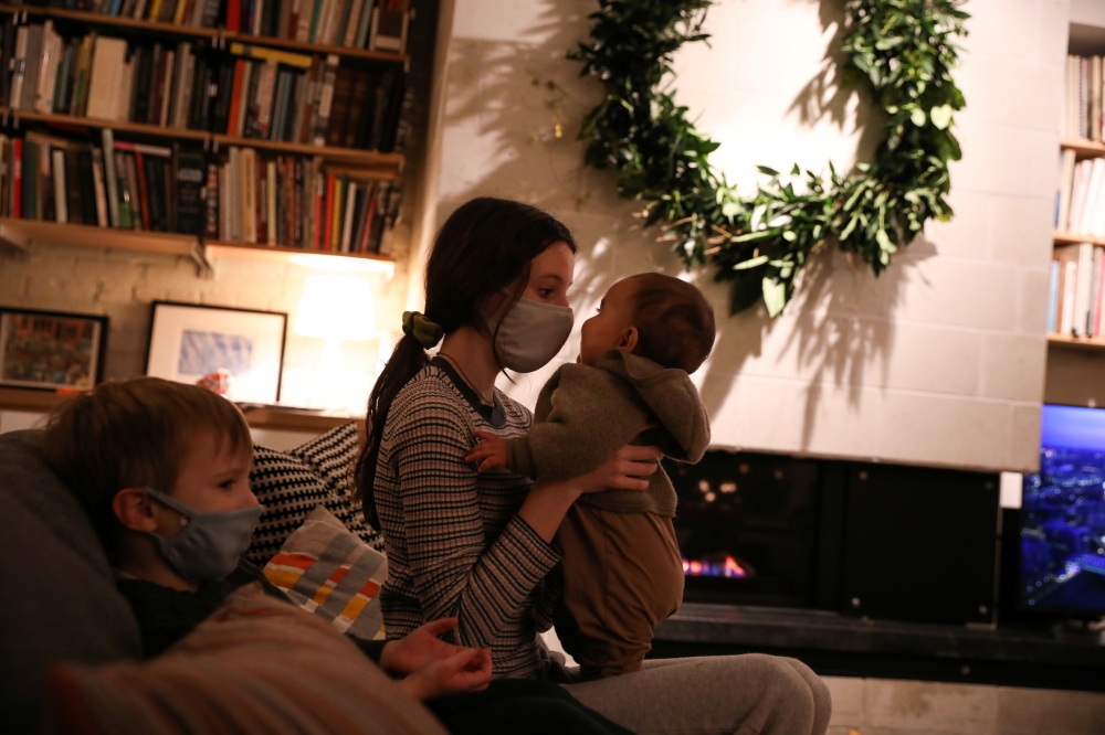 Jane Hassebroek holds her cousin while sitting next to her brother Felix, as the global outbreak of the coronavirus disease (COVID-19) continues, in New York City, U.S., December 6, 2020. REUTERS/Caitlin Ochs