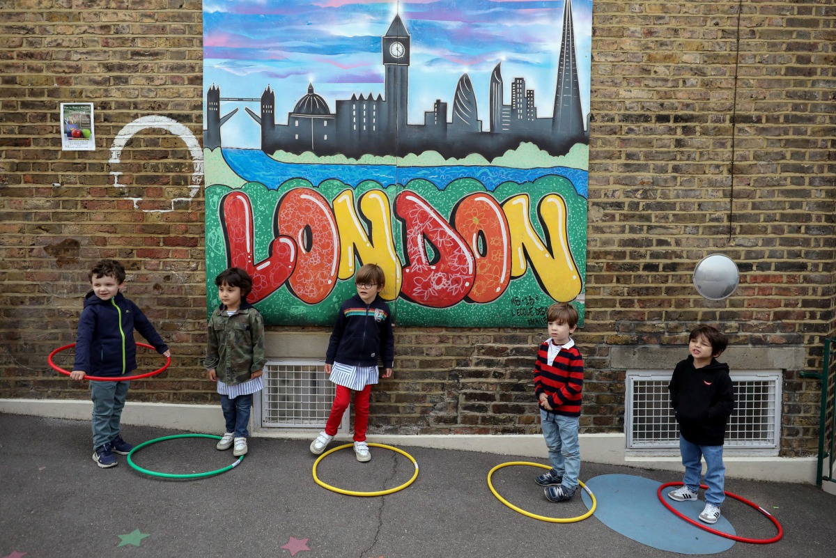 FILE PHOTO: Children use hoops for social distancing at L'Ecole des Petits, an independent French bilingual school, as the coronavirus disease (COVID-19) lockdown eases in Fulham, London, Britain, June 9, 2020. REUTERS/Kevin Coombs 