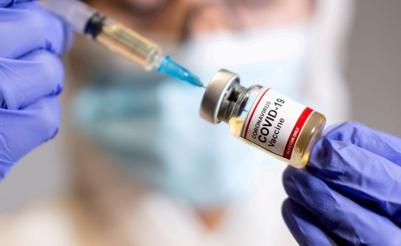 FILE PHOTO: A woman holds a small bottle labeled with a 