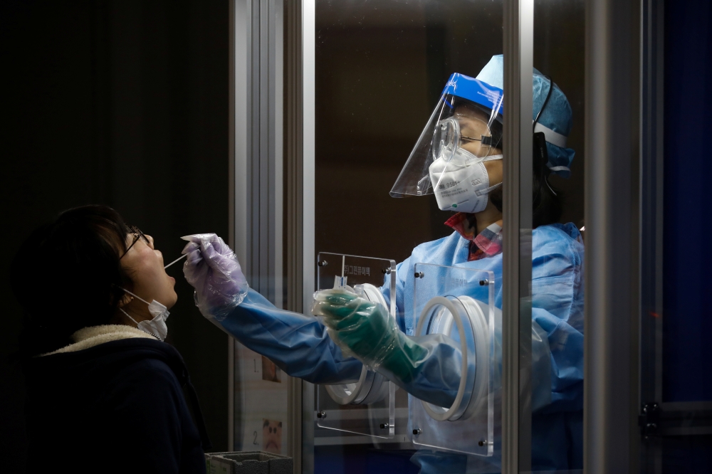 A woman undergoes a coronavirus disease (COVID-19) test at a testing site in Seoul, South Korea, December 13, 2020. REUTERS/Kim Hong-Ji