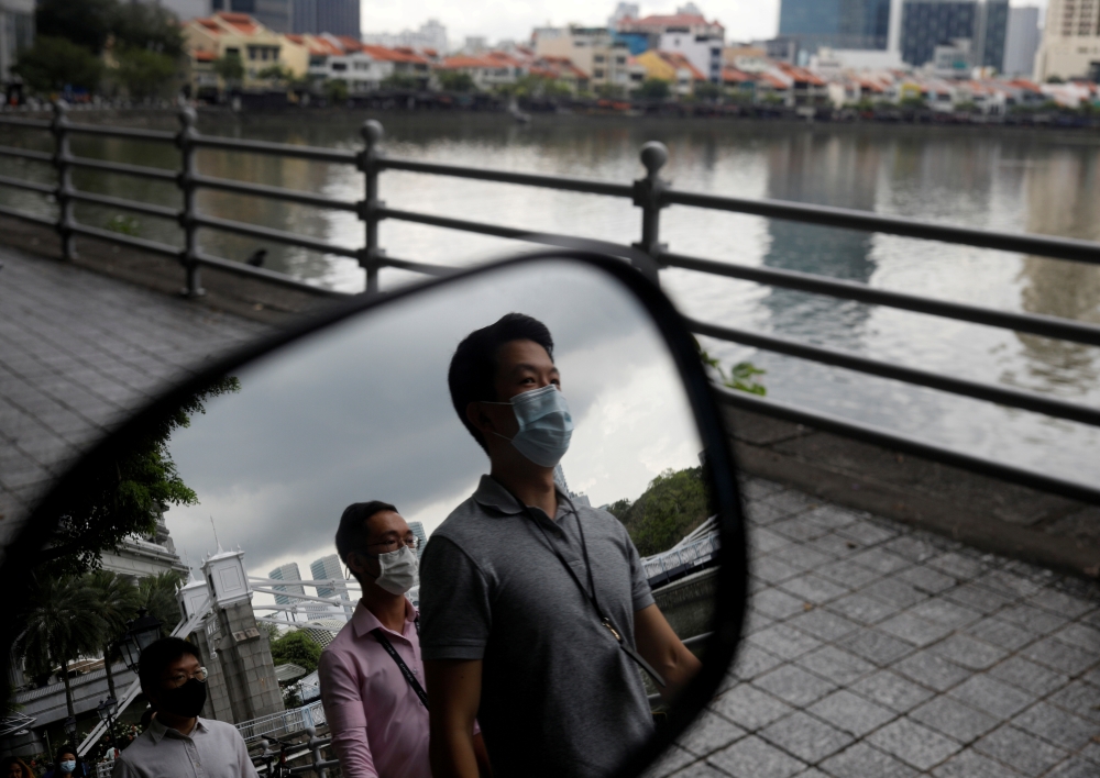 People wearing face masks as a precaution against the coronavirus disease (COVID-19) walk during lunch hour at the central business district in Singapore, December 14, 2020. REUTERS/Edgar Su/File Photo