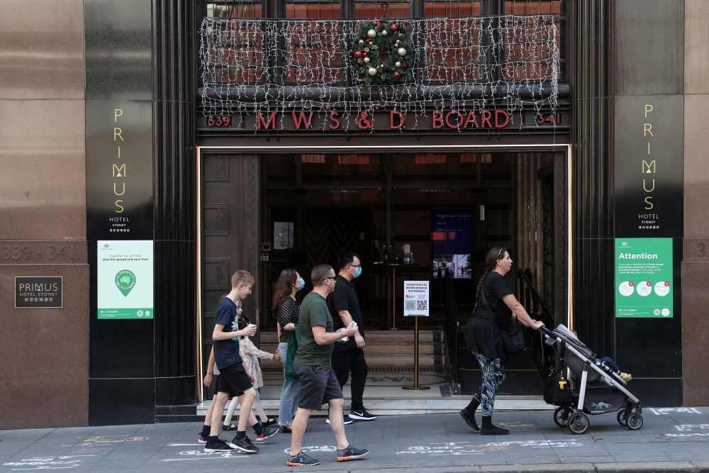 People walk past a hotel decorated for the holidays in the city centre of Sydney, Australia, December 17, 2020. REUTERS/Loren Elliott
