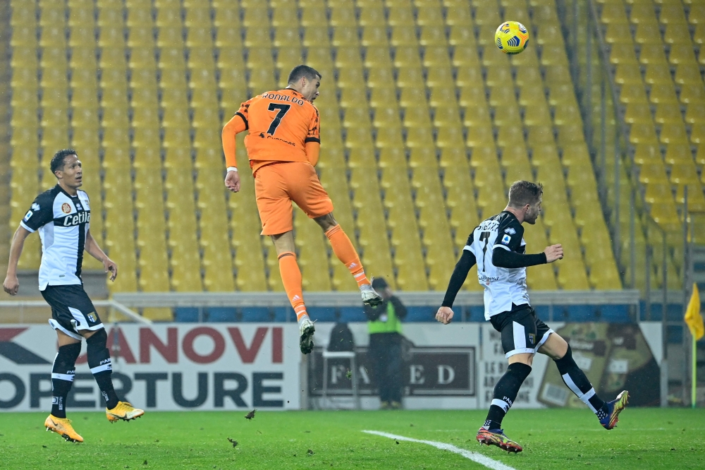 Juventus' Portuguese forward Cristiano Ronaldo jumps to score a header during the Italian Serie A football match Parma vs Juventus on December 19, 2020 at the Ennio-Tardini stadium in Parma. / AFP / Alberto Pizzoli 