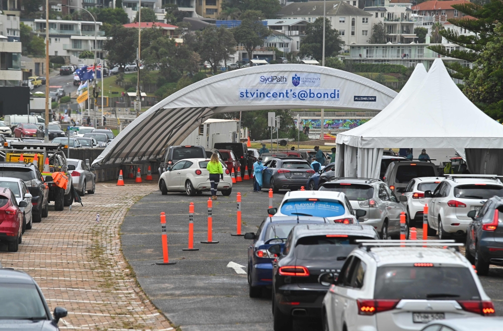 People queue in cars at a COVID-19 drive-through testing centre at Bondi Beach in Sydney on December 20, 2020. / AFP / Steven Saphore
