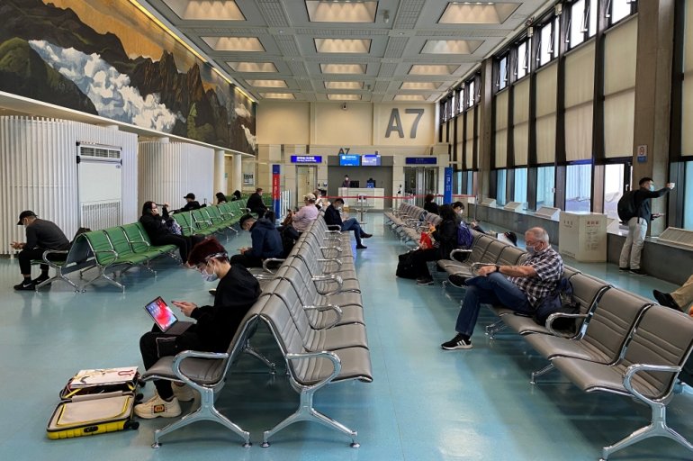 Passengers wearing masks practice social distancing to prevent the spread of the coronavirus disease (COVID-19), as they wait to board a flight at Taipei’s Taoyuan International Airport, in Taiwan, October 23, 2020. REUTERS/Ben Blanchard