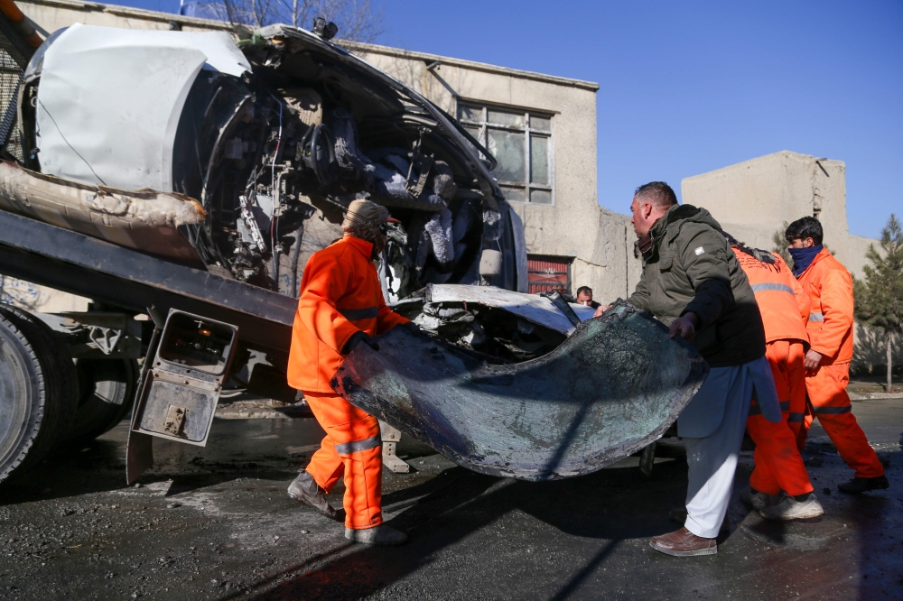 Municipal workers clean up debris at the site of a bomb attack in Kabul on December 22, 2020. AFP / Zakeria Hashimi 