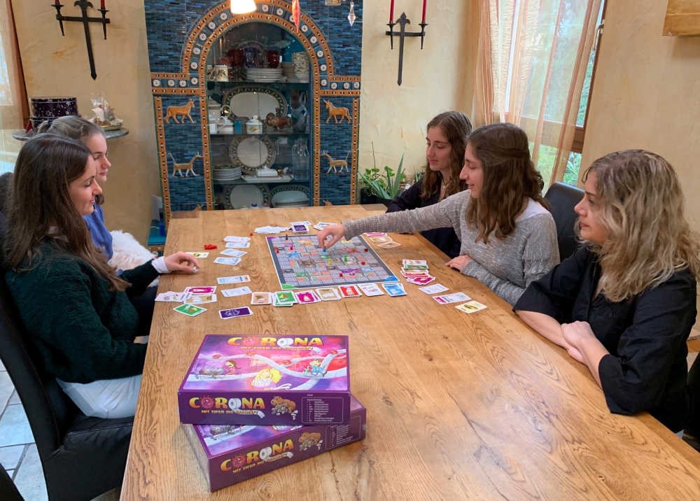 Rebecca, Lara, Stella, Sarah und Paulette Schwaderlapp play 'Corona - the rush to the shops' board game invented by Lara and Sarah to pass away the time in lockdown, in Wiesbaden Biebrich, Germany, December 20, 2020. Reuters/Annkathrin Weiss