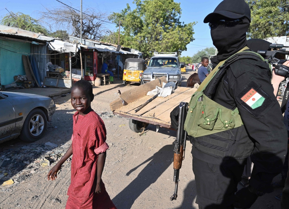 A Nigerien police officer stands in the road near the Diffa airport in South-East Niger, near the Nigerian border, on December 23, 2020.  AFP / Issouf SANOGO