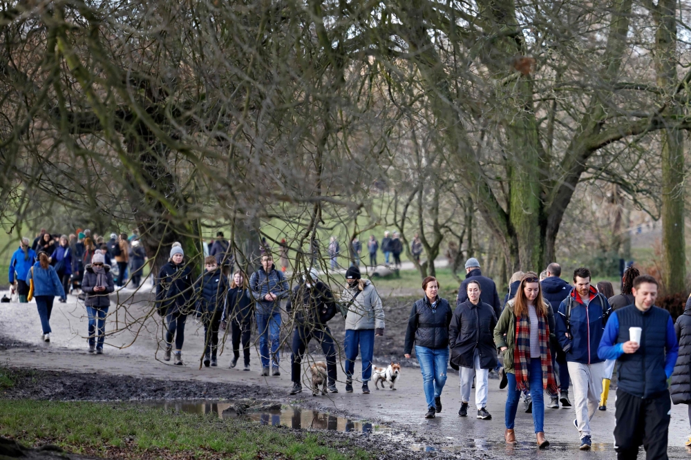 Members of the public enjoy a stroll on Hampstead Heath in London on December 27, 2020, as Londoners continue to live under Tier 4 lockdown restrictions. (AFP / Tolga Akmen)