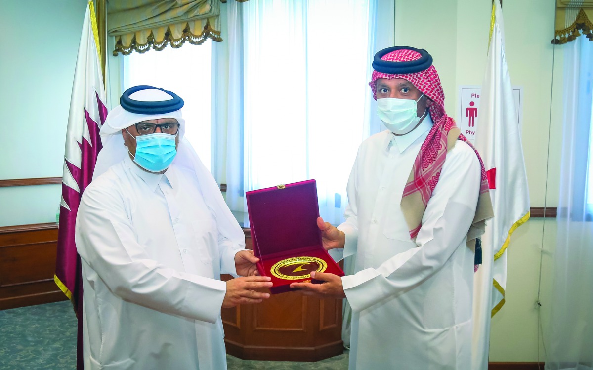 Chief Executive Director of Qatar Red Crescent Society (QRCS), Eng. Ibrahim Abdullah Al Maliki, and Chairman of Qatar Association of Certified Public Accountants (QCPA), Dr. Hashem Al Sayed, exchanging documents. 