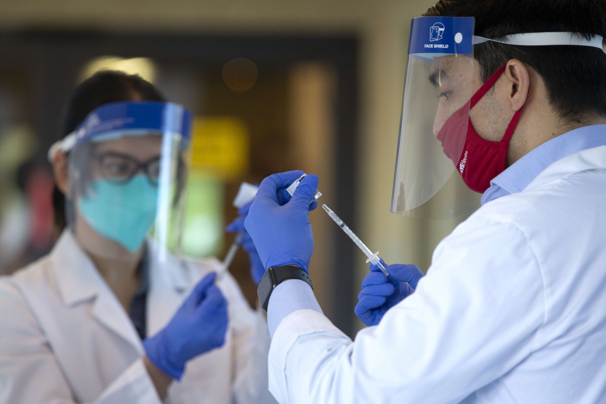 KIRKLAND, WA - DECEMBER 28: Pharmacists prepare doses of the COVID-19 vaccine at the Life Care Center of Kirkland on December 28, 2020 in Kirkland, Washington. The Life Care Center of Kirkland, a nursing home, was an early epicenter for coronavirus outbre