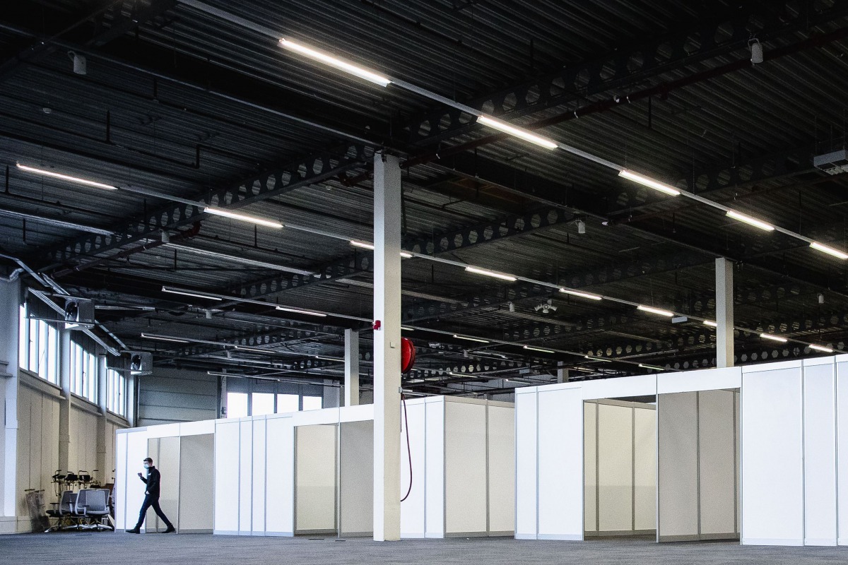 An employee walks past portacabins in the Expo Houten, in Houten on December 30, 2020, as part of the locations setting-up for the Dutch national Covid-19 vaccination campaign to fight against the spread of the novel coronavirus. / AFP / ANP / Sem van der