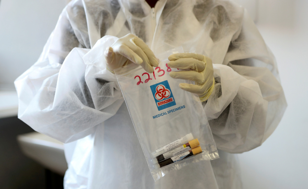 FILE PHOTO: A health worker holds a COVID-19 sample collection kit of a vaccine trials' volunteer, after they were tested for the coronavirus disease and take part in the country's human clinical trial for potential vaccines at the Wits RHI Shandukani Res