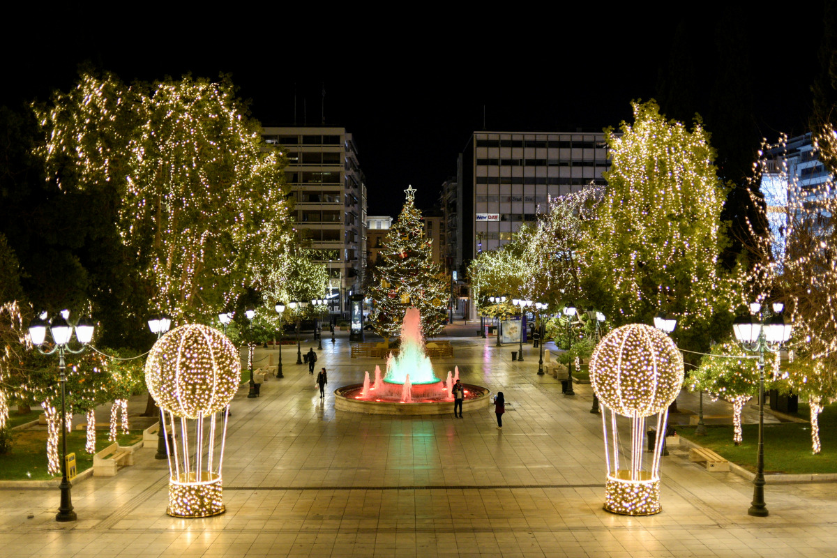 People make their way on the Christmas-decorated Syntagma square before New Year's day celebrations, amid the coronavirus disease (COVID-19) pandemic in Athens, Greece, December 31, 2020. Picture taken December 31, 2020. REUTERS/Louiza Vradi
